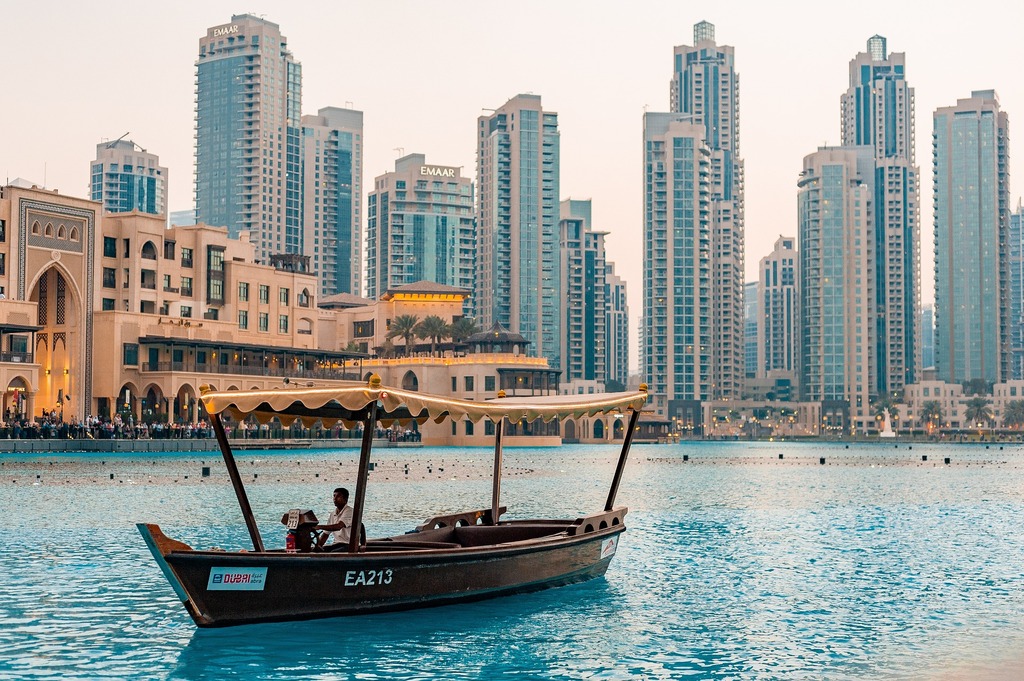 An abra on Burj Lake beside Dubai Mall, with Downtown Dubai towers behind it